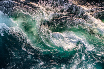 Blue waves of water of the river and the sea meet each other during high tide and low tide.