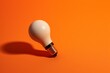 An illuminated bulb on an orange backdrop casting a bulb shadow. Generative AI