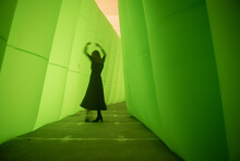 Silhouette Of A Woman In A Black Dress Dancing In A Green Tunnel 