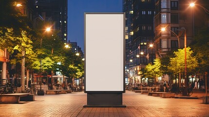 Canvas Print - Blank mock up of vertical street poster billboard on city background. Electronic modern empty scoreboard on the background of a city street in the evening. copy space