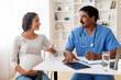 © Prostock-studio - Gynecology Consultation. Smiling indian pregnant woman visiting obstetrician doctor in maternity clinic