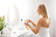 Beauty Care Concept. Smiling Middle Aged Woman Opening Jar With Moisturising Cream