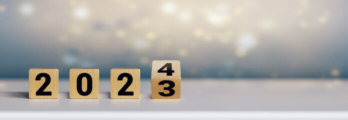 Wooden cubes on white table symbolizing the turn of the year (2023 / 2024)