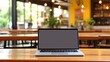 © JuJamal - Blank screen laptop mockup with a cup of coffee in cafe