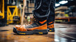 © PaulShlykov - Close-up safety working shoe on a worker feet is standing at the factory, ready for working in danger workplace concept. Industrial working scene and safety equipment.