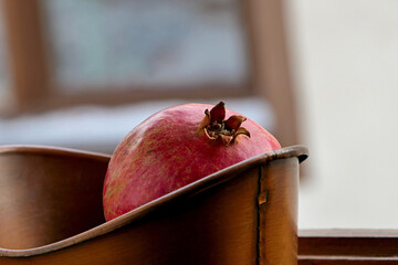 Wall Mural - pomegranate in a copper pot on wooden background