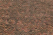 Vintage red roof terracotta tile. Old roof tiles background. Texture ancient dilapidated tiles with moss, broken, ruined tile. Red brown roof tiles in Buddhist temple near Vietnam. Top view