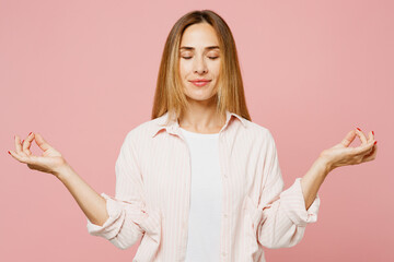 Wall Mural - Young spiritual woman she wear shirt white t-shirt casual clothes hold spreading hands in yoga om aum gesture relax meditate try to calm down isolated on plain pastel pink background studio portrait.