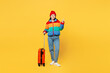 © ViDi Studio - Traveler woman wear padded windbreaker jacket red hat hold suitcase bag point aside isolated on plain yellow background Tourist travel abroad in free time rest getaway Air flight trip journey concept