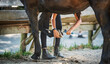 A girl cleans the horse's hooves after a ride
