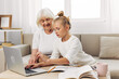© SHOTPRIME STUDIO - Child grandmother selfie hugging bonding granddaughter family sofa laptop smiling togetherness