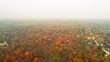 Super wide aerial shot of colorful autumn tree's changing color in a countryside neighborhood in the Midwest. 
