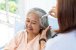 Close-up photo of an nurse combs the hair of an elderly Asian patient and offers a pep talk.