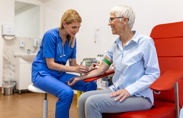 Preparation for blood test with senior woman by female doctor medical uniform on the table in white bright room. Nurse pierces the patient's arm vein with needle blank tube.