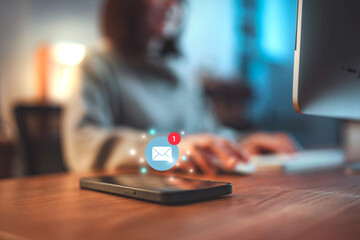 Smart phone mobile receiving mail message, email notification, Woman employee use mobile phone after receiving an email message while sitting at work desk at night