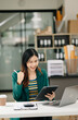 © Nuttapong punna - Asian business woman are delighted and happy with the work they do on their tablet, laptop and taking notes at the modern office.