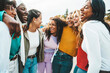 Multi ethnic group of young women hugging outside - Happy girlsfriends having fun laughing out loud on city street - Female community concept with cheerful girls standing together - Women  power