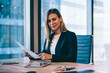 © BullRun - Portrait of successful mature female entrepreneur sitting at desktop in office company