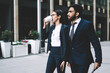 © BullRun - Successful diverse traders walking on modern city streets on way for meeting with business partners