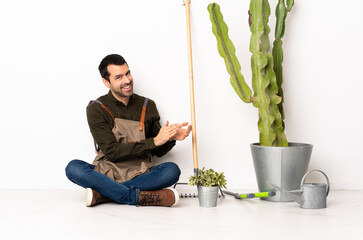 Poster - Gardener man sitting on the floor at indoors applauding