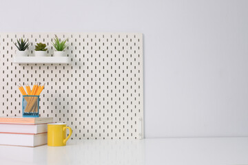 Stylish desk interior with White table background with plant and leaves. Modern home office interior