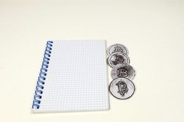 Popular cryptocurrency most famous coin in the world bitcoin with notepad on white background.