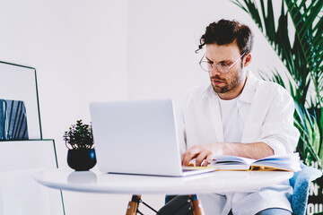 Poster - young man spending time in own apartment with laptop computer