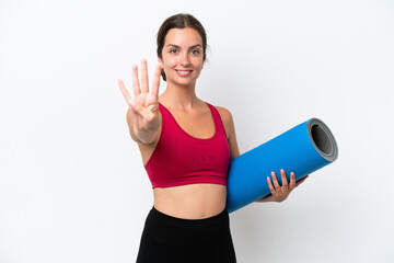 Poster - Young sport caucasian woman going to yoga classes while holding a mat isolated on white background happy and counting four with fingers