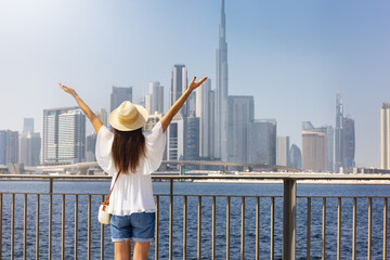 Sticker - A happy tourist woman enjoys the view of the modern skyline of Dubai, UAE