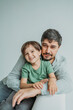 © Westend61 - Smiling man with son sitting on sofa against white background