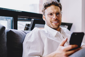 Poster - positive man smiling and holding smartphone gadget