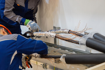 Poster - production power cables. hands workers connecting thick electrical wires. manufacturing power cables