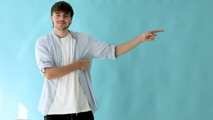 Poster - young man isolated on background pointing to space