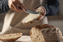 A Woman Makes Delicious Bread, Spreads Cream Cheese With A Cutlery Knife - Close Up. Woman Hands Spreading Cream Cheese On Bread Slice.