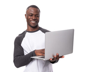 Wall Mural - young african guy with short haircut is using laptop for remote work