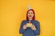 © VISTA by Westend61 - Smiling woman with dyed hair holding birthday cake