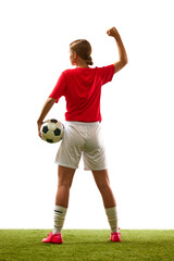 Wall Mural - Full-length back view of young woman, football player in uniform standing with ball on grass field isolated on white background. Concept of sport, competition, action, success, win. Copy space for ad