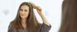 © Alliance - Happy young woman combing hair in bathroom