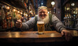 Happy bearded senior man bartender with beer while standing near the bar counter. Portrait of cheerful barman showing thumb up at pub.