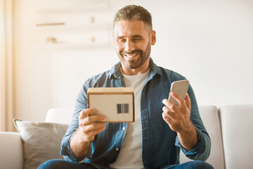 Poster - Happy middle aged man unboxing newly purchased mobile phone indoor