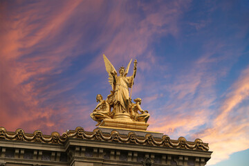 Golden statue of Liberty on the roof of the Opera Garnier (Garnier Palace)  against the sky at sunset. Sculpted by Charles Gumery in 1869. Paris, France. UNESCO World Heritage Site