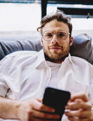 Poster - Close up portrait of positive caucasian hipster guy in optical spectacles for vision correction