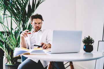 Poster - serious caucasian man using modern netbook for online job browse and downloading files
