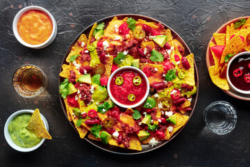 Poster - Loaded nachos. Mexican nacho chips with beef, overhead flat lay shot with guacamole sauce, cheddar cheese salsa, chili, jalapenos, and tequila drinks