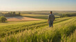 © Enrique - A farmer in a field looking down at the harvest, in a green wheat field