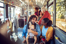 Happy Multiethnic Family Traveling By Public Bus