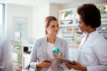 A Focused Customer Listens Intently To The Pharmacist's Advice