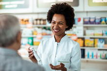 Pharmacist explains medication details to an attentive senior patient