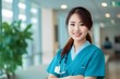 © A Denny Syahputra - Asian female nurse in hospital corridor smiling