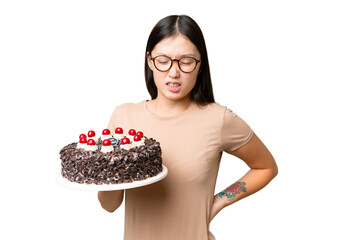 Wall Mural - Young Asian woman holding birthday cake over isolated chroma key background suffering from backache for having made an effort